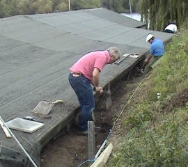 Clearing the drainage channel behind the clubhouse